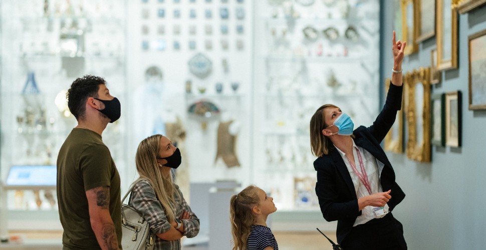 Family listening to a guide speak in The Box